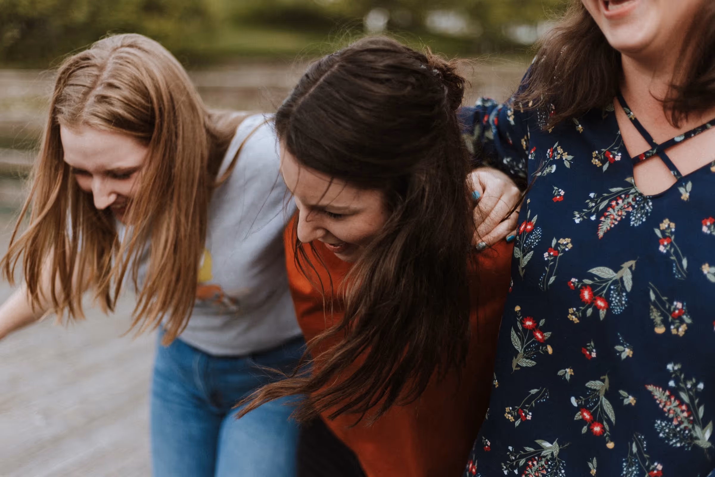 Three girls laugh together showing gratitude towards each other.