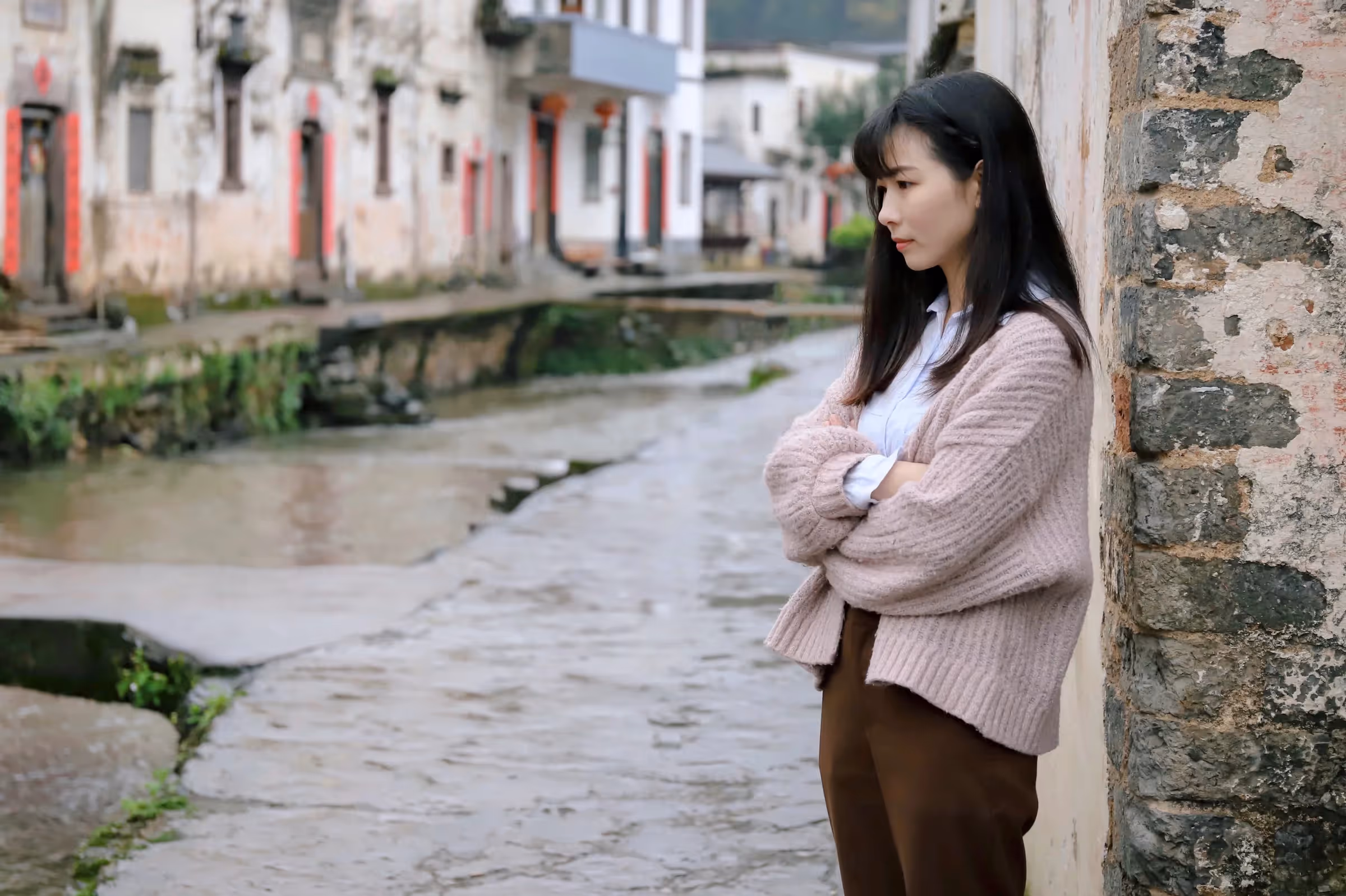 A woman stands dejected and filled with jealousy.