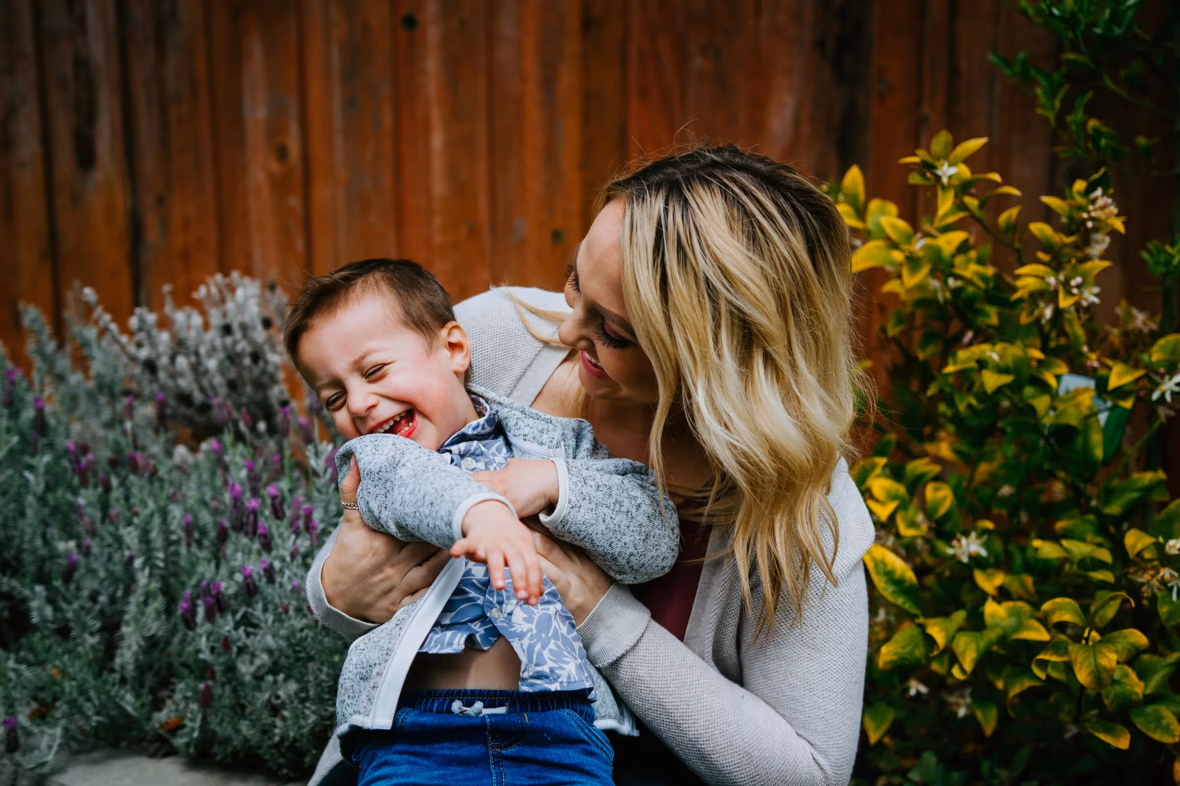 A mother holds her child and plays.